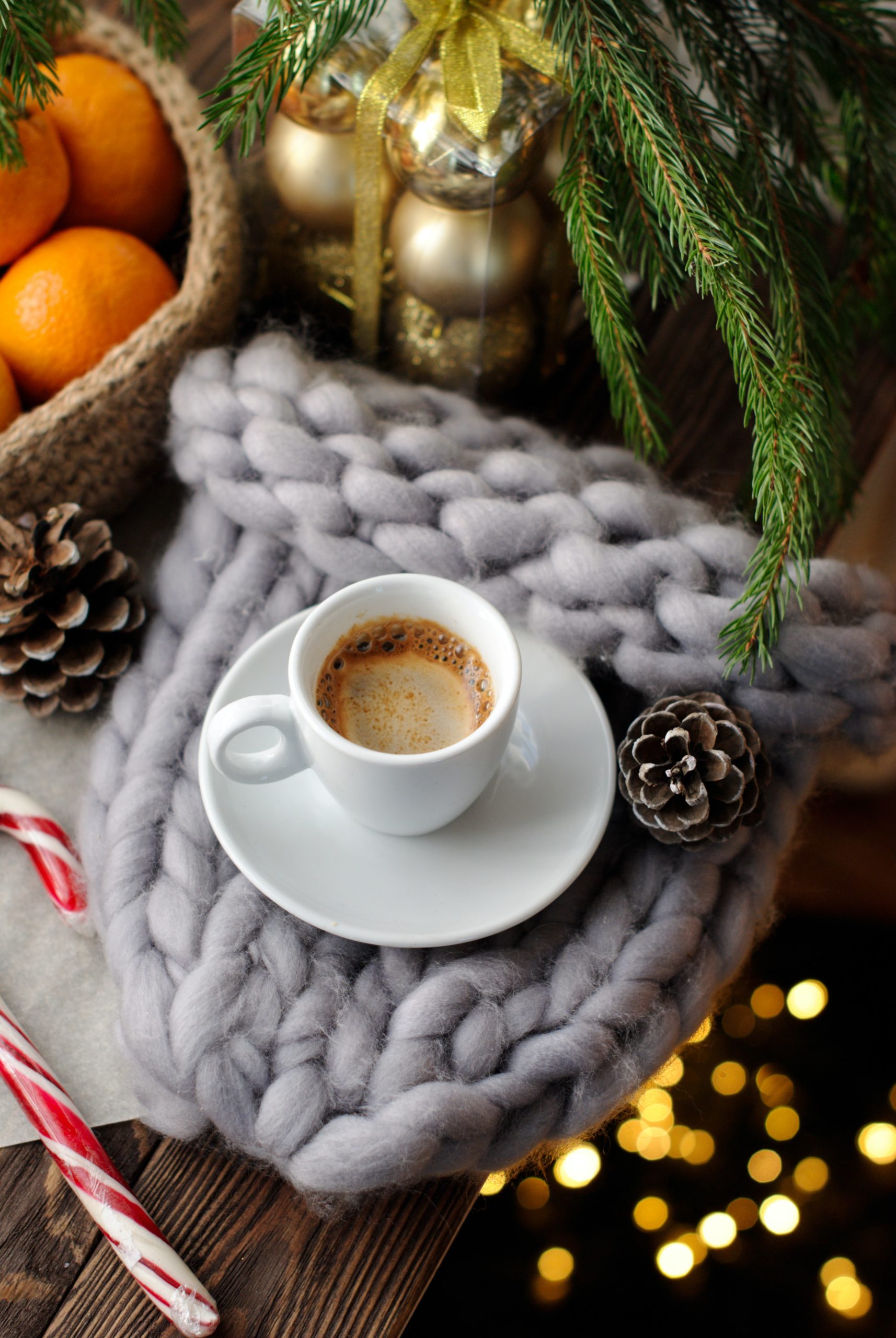 Seasonal flatlay of coffee on a holiday knitted blanket