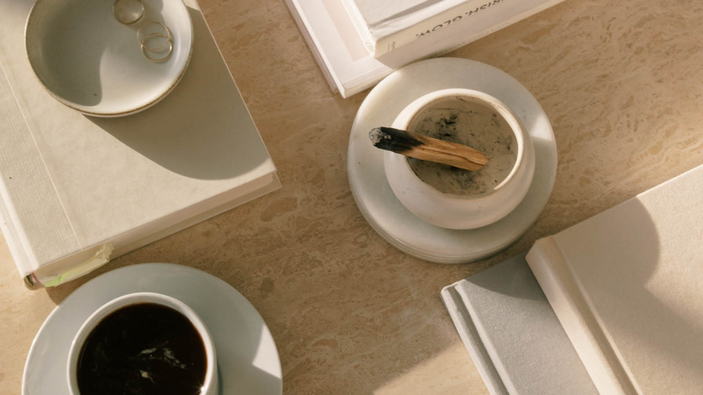 The Power of Daily Habits in Business Success | Overhead photo of a table with coffee, books and palo santo